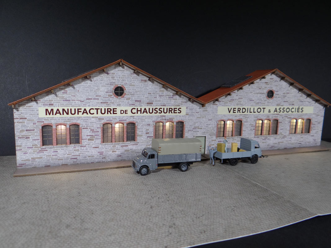 Fond de décor en relief d´une usine avec baies éclairées "Manufacture de chaussures"