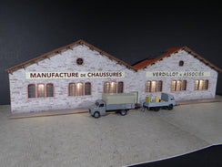 Fond de décor en relief d´une usine avec baies éclairées "Manufacture de chaussures"